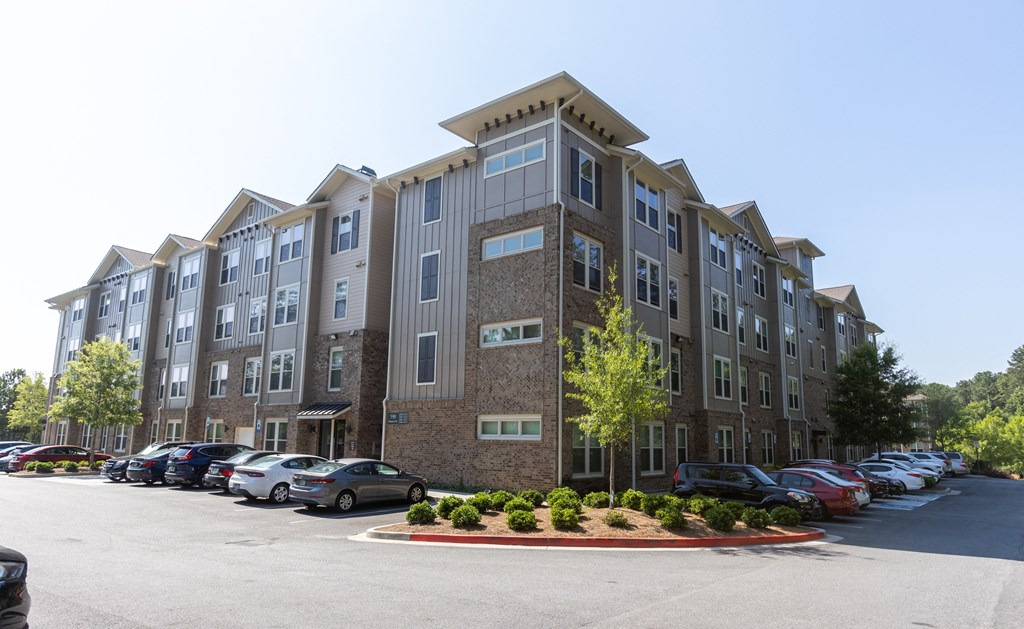 a large apartment building with a parking lot in front of it