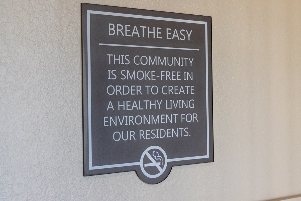 a sign that says breathe easy this community is smoke free in order to create a healthy living