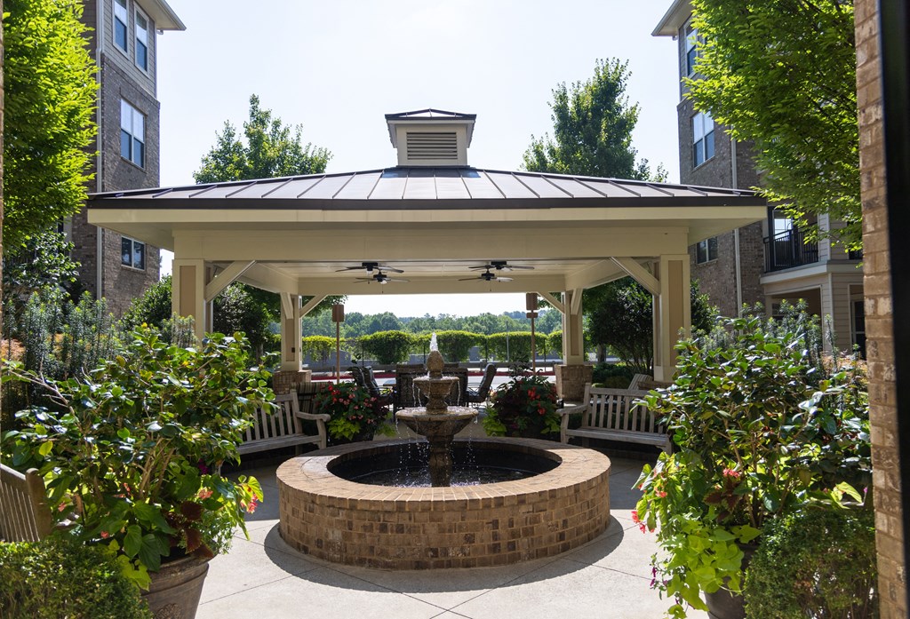 a gazebo with a fountain in the middle of a courtyard