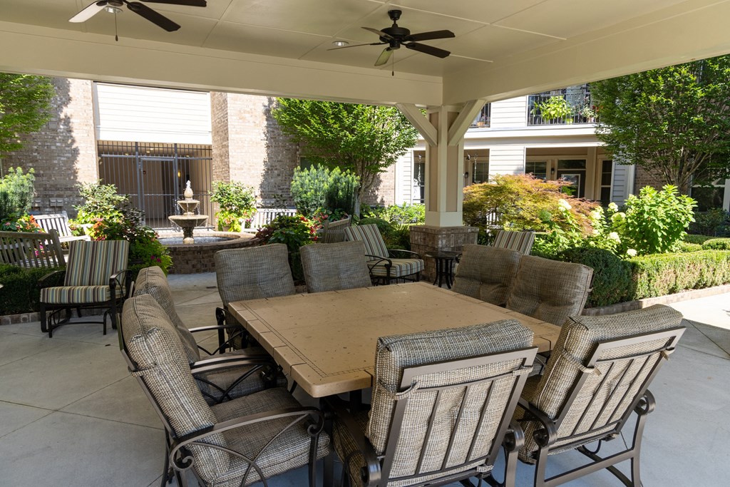 a covered patio with a table and chairs