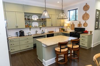 a kitchen with a island and three stools in front of a counter top