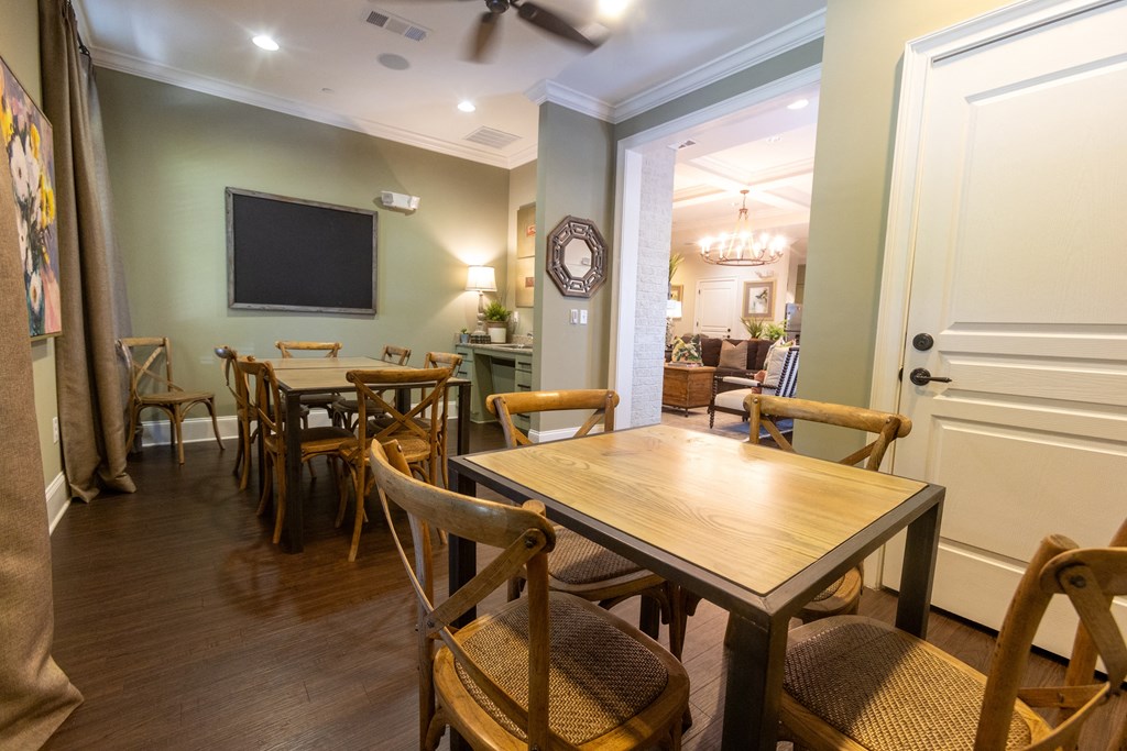 a dining room with tables and chairs and a tv on the wall