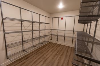 a large walk in closet with metal shelving and a staircase