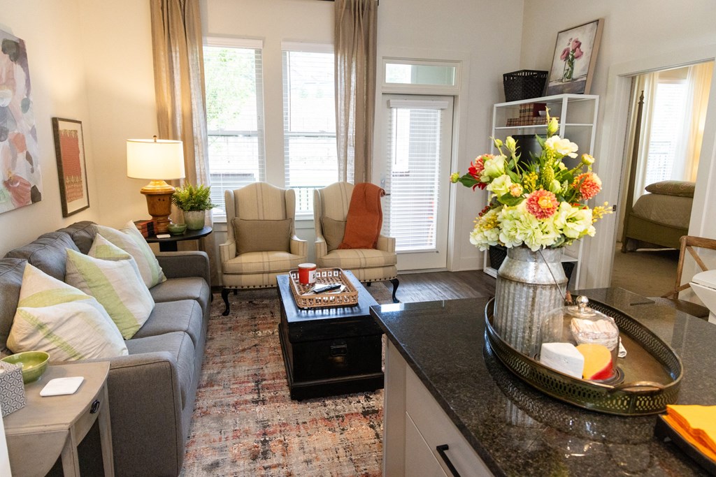 a living room filled with furniture and a table with a vase of flowers on top of
