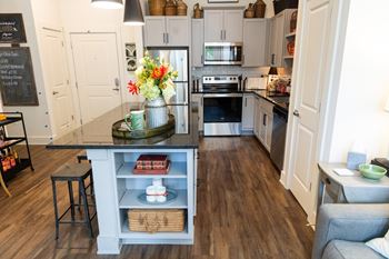 The Legacy at Walton Kennesaw Mountain active adult community in Cobb County, GA a kitchen with a center island with a vase of flowers on top of it