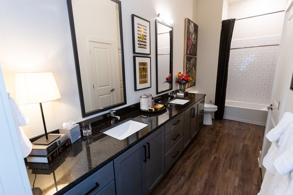 a bathroom with a long vanity with two sinks and two mirrors