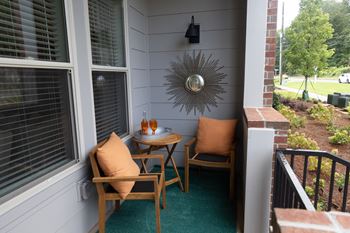 a small balcony with two chairs and a small table