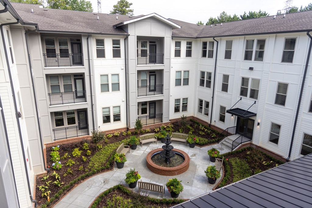 an aerial view of a courtyard with a fountain and potted plants