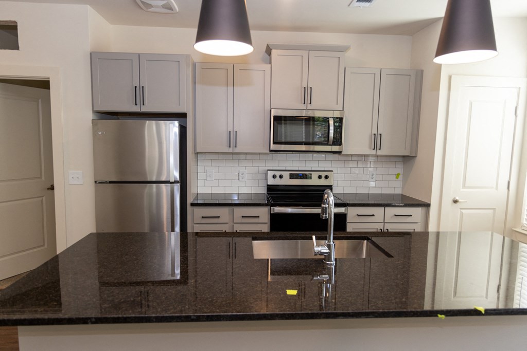 a kitchen with granite countertops and stainless steel appliances