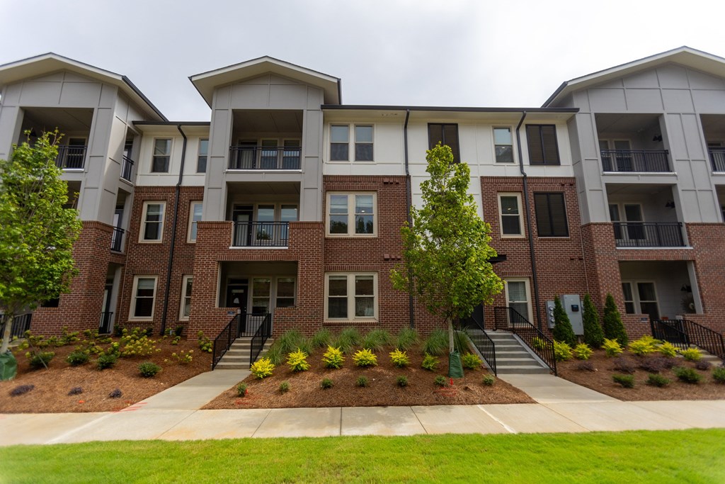 an apartment building with a sidewalk in front of it