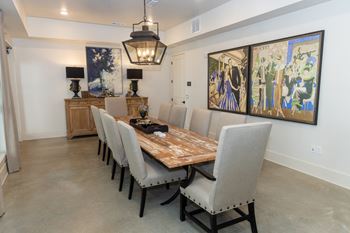 a dining room with a long wooden table and gray chairs