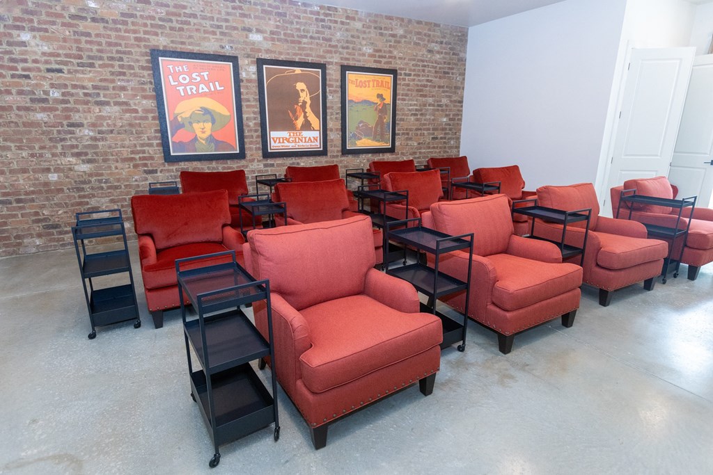 a seating area with red chairs and black stools
