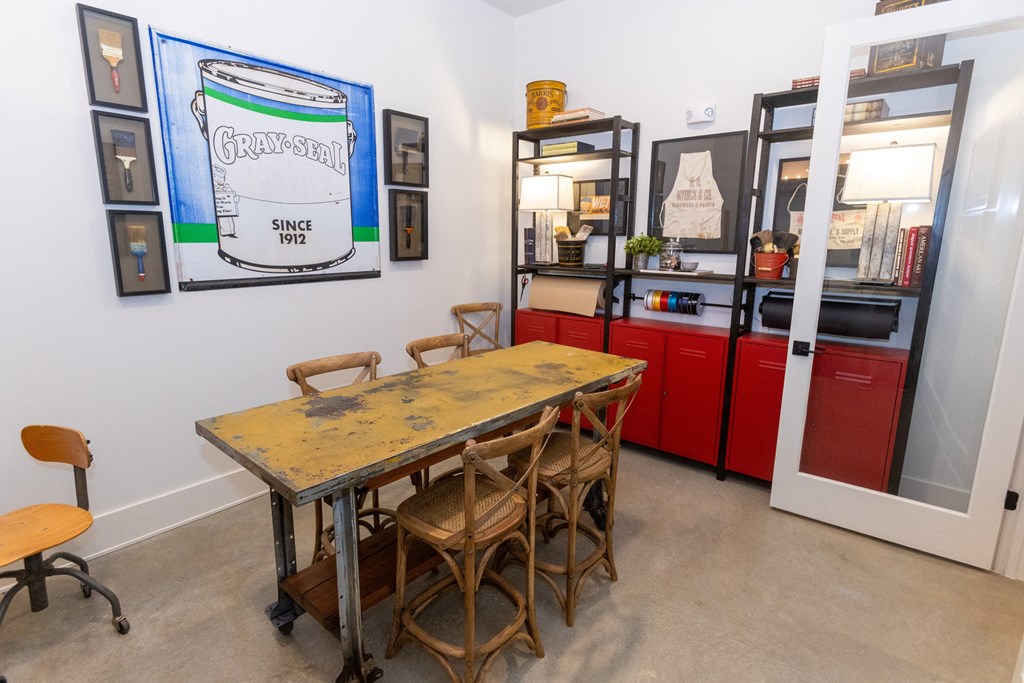 a dining room with a table and chairs in front of a red refrigerator
