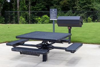 a picnic table with a grill and a mailbox