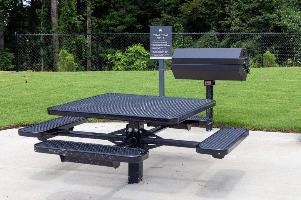 a picnic table with two benches and a grill