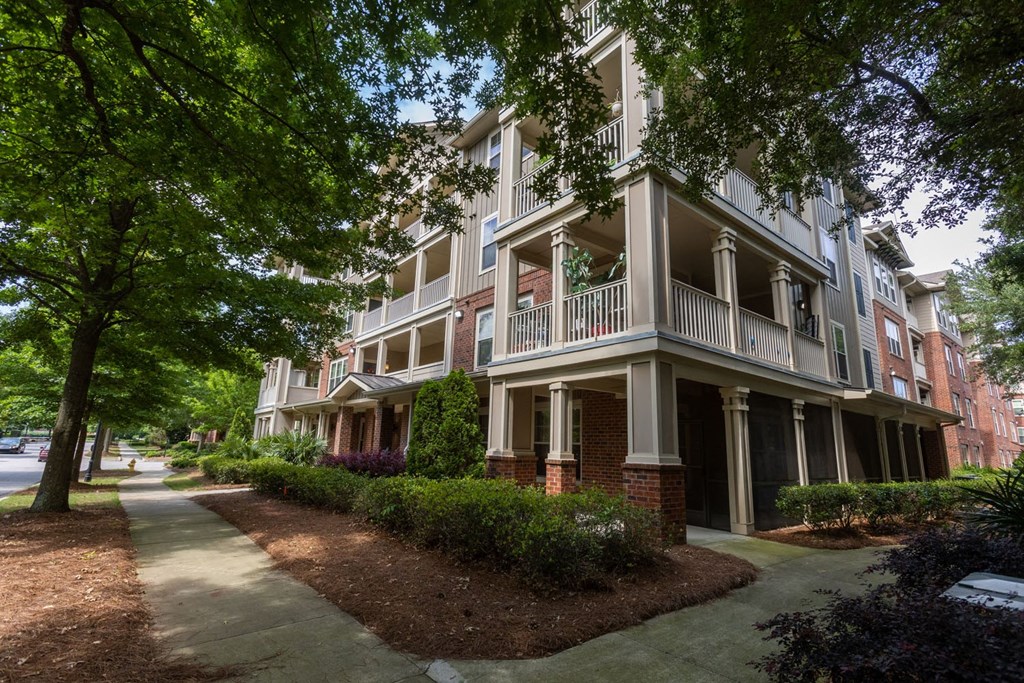 an apartment building with a sidewalk in front of it