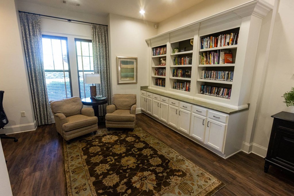 a living room with two chairs and a bookcase