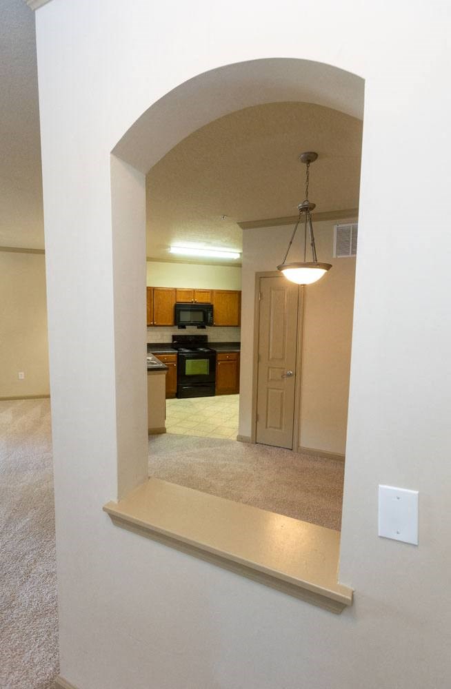 a hallway with a light and a kitchen in the background