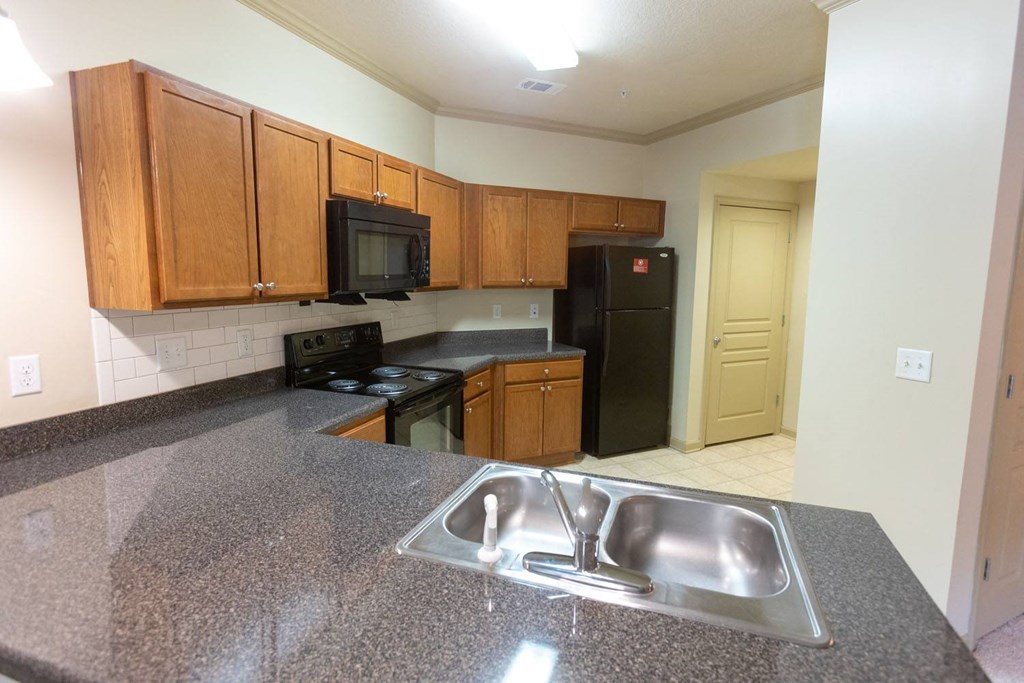 a kitchen with a sink stove refrigerator and microwave