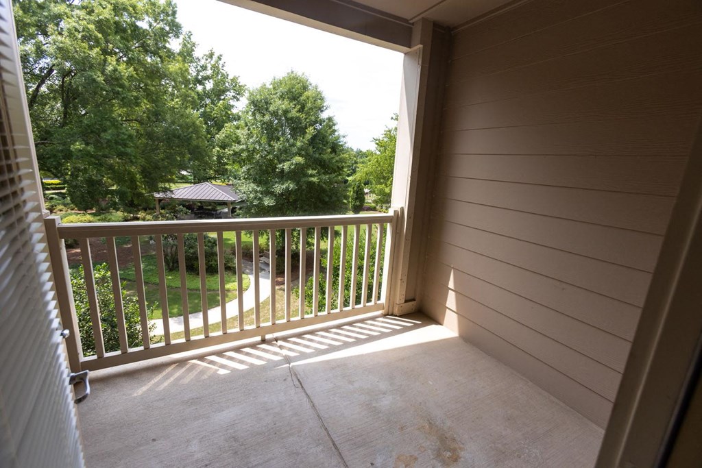 a balcony with a view of a yard and trees
