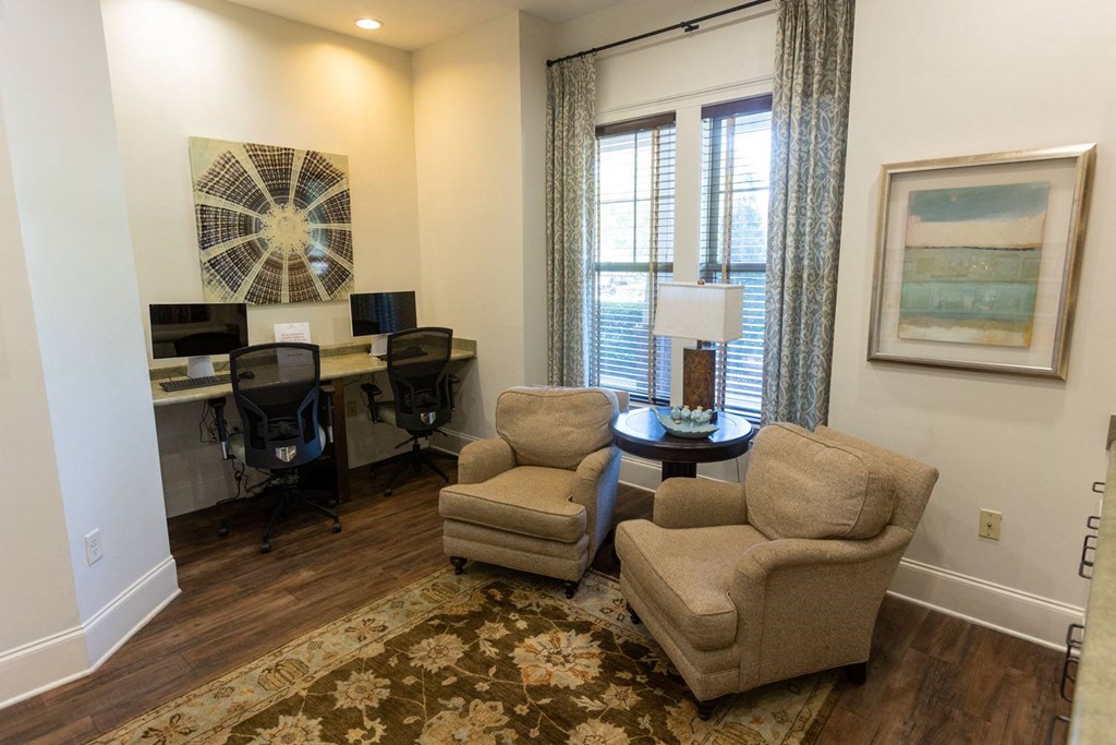 a living room with two chairs and a table with a lamp