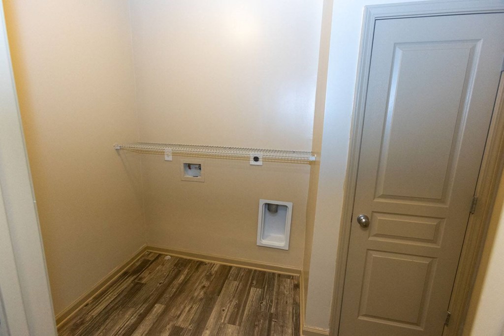 a small room with a white door and a wooden floor