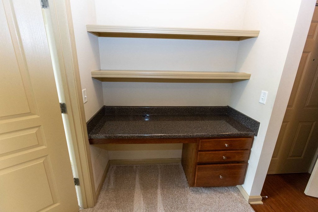 a home office with a desk and drawers