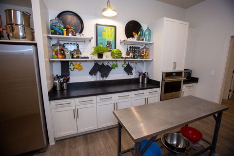 A kitchen with a table and a fridge.