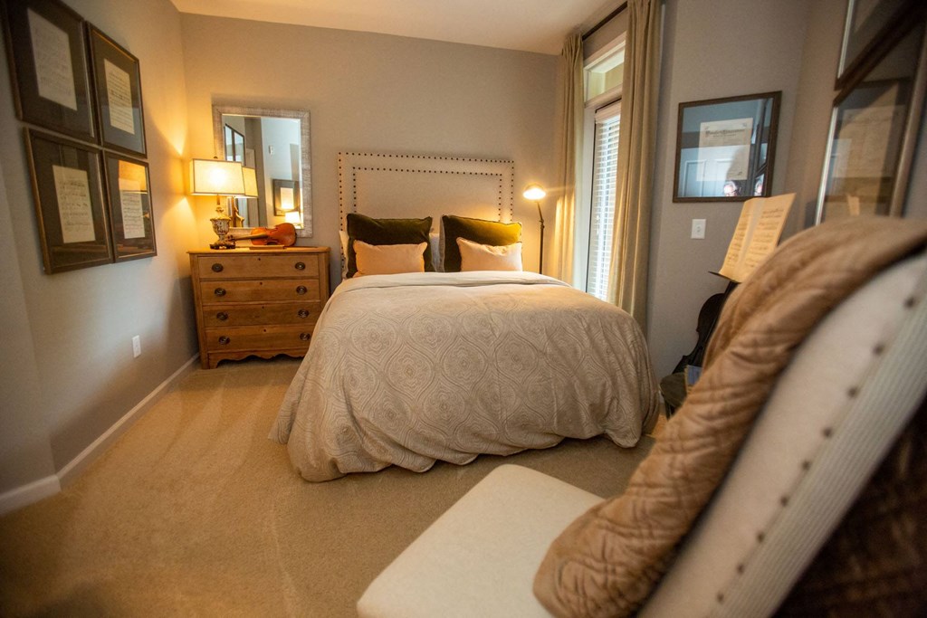 a bedroom with a bed and a dresser and a window