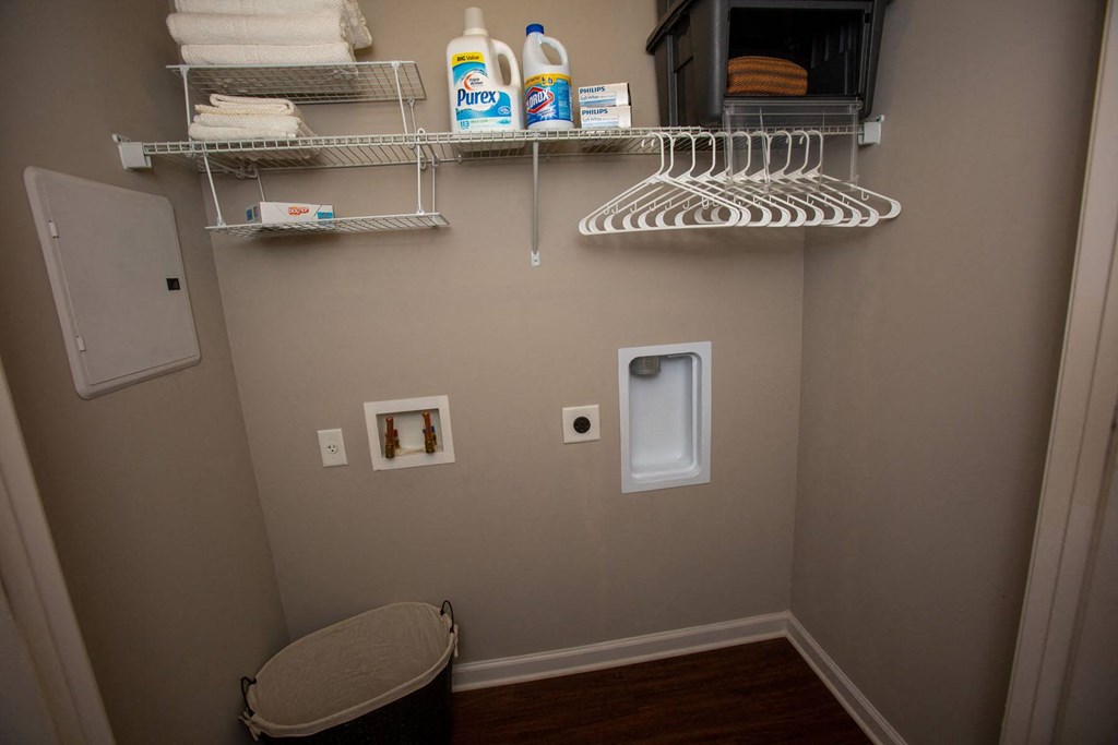 a small bathroom with a dryer and shelves on the wall