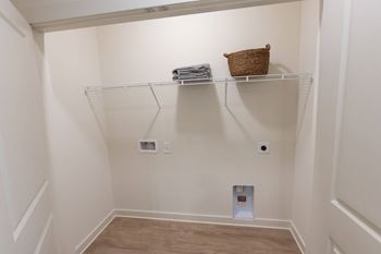 A small closet with a basket on the shelf.