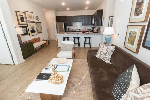 A brown couch sits in a living room with a coffee table in front of it.