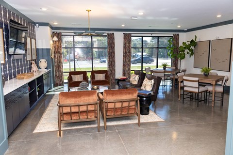 A living room with a brown couch and a dining table.