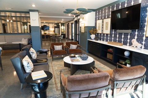 A living room with a black table and brown chairs.