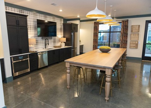 A modern kitchen with a wooden table and stainless steel appliances.