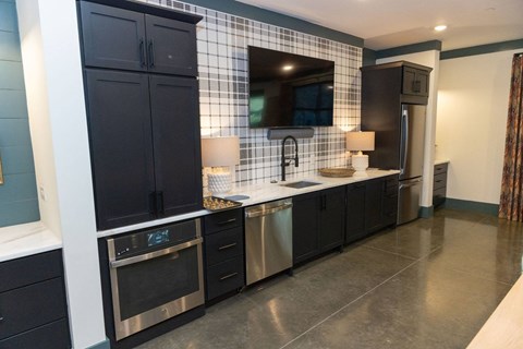 A modern kitchen with black cabinets and stainless steel appliances.