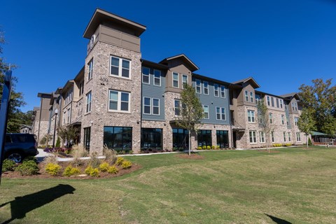 A large, modern building with a stone facade and multiple windows.