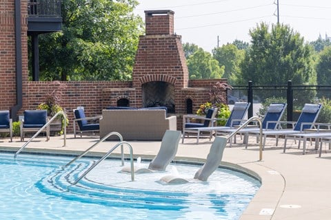 a pool with a brick fireplace in the background