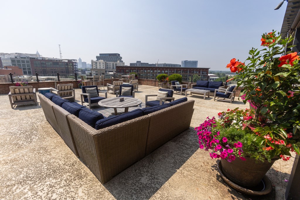 a terrace with couches and chairs on top of a building