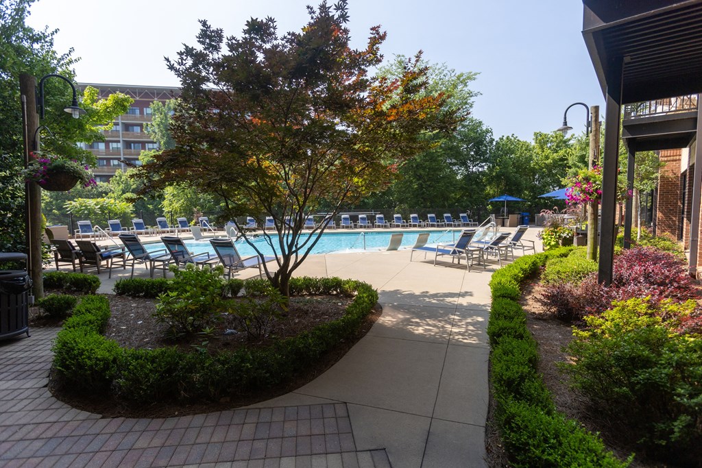 a swimming pool with chaise lounge chairs and a building in the background
