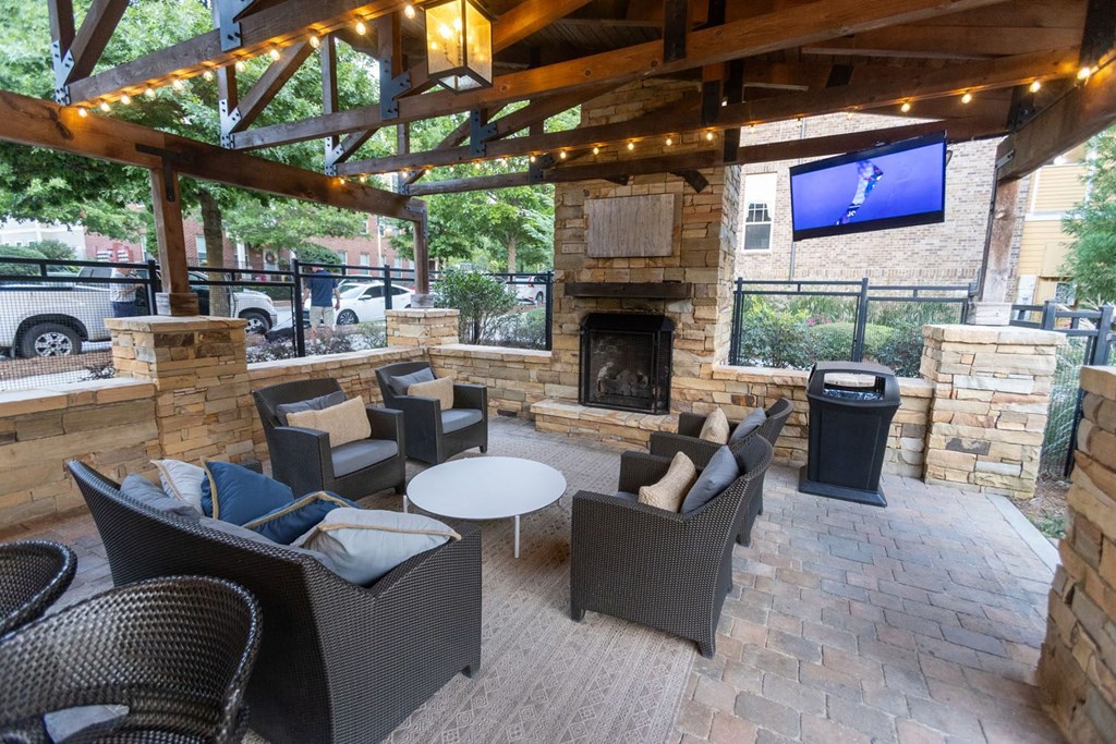 a patio with chairs and a fireplace and a tv