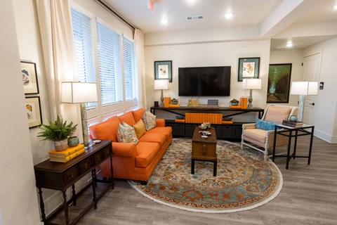 A living room with a large orange couch and a coffee table.