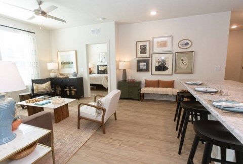 A living room with a couch, chairs, and a dining table.