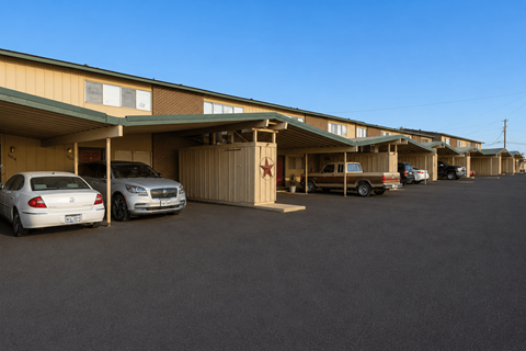 A parking lot with a building and two cars.