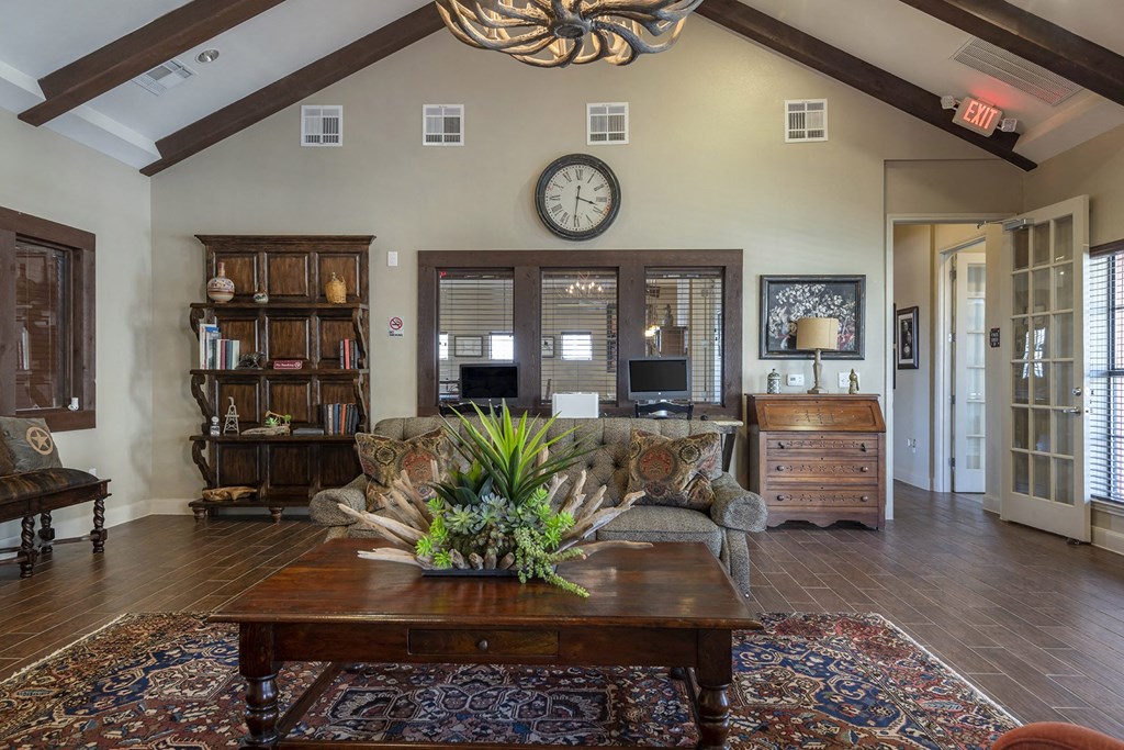 A living room with a wooden coffee table and a large chandelier.