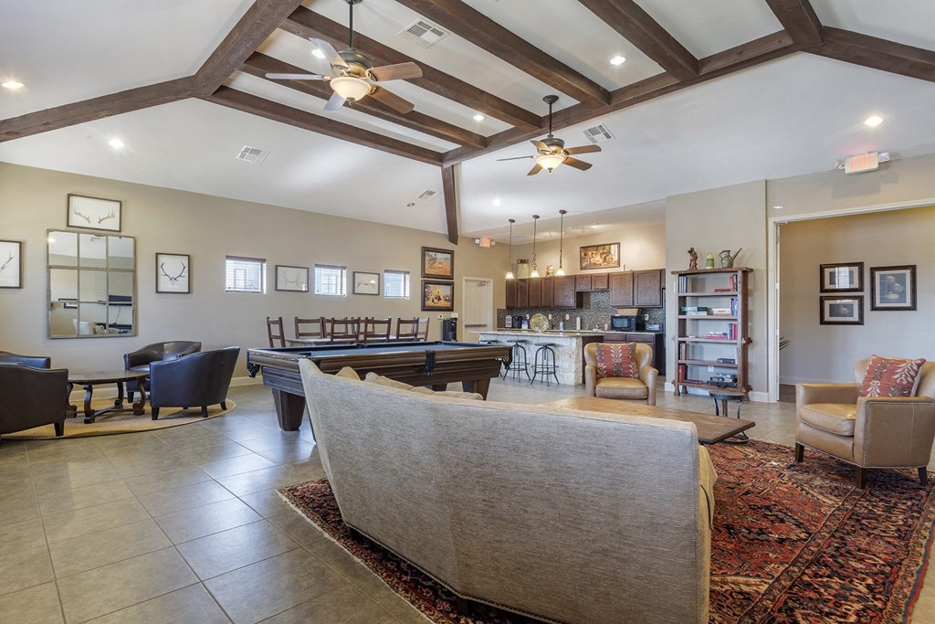 A living room with a couch, chairs, and a rug.