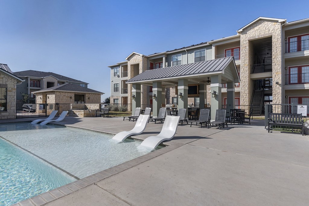 A large swimming pool in front of apartment buildings.