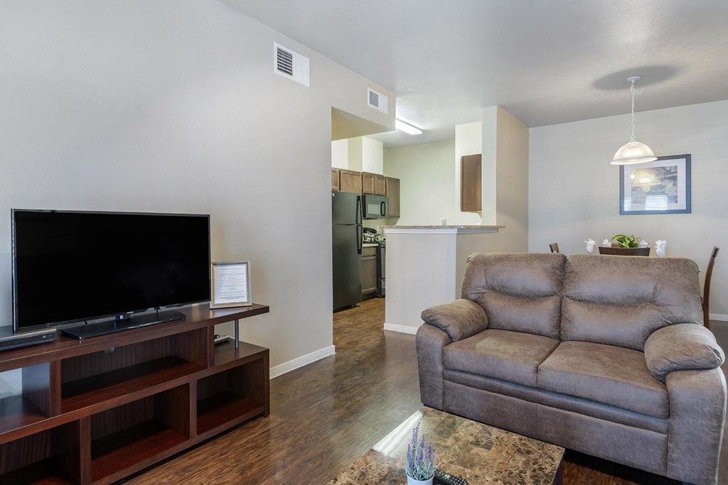 A living room with a grey couch and a black television.