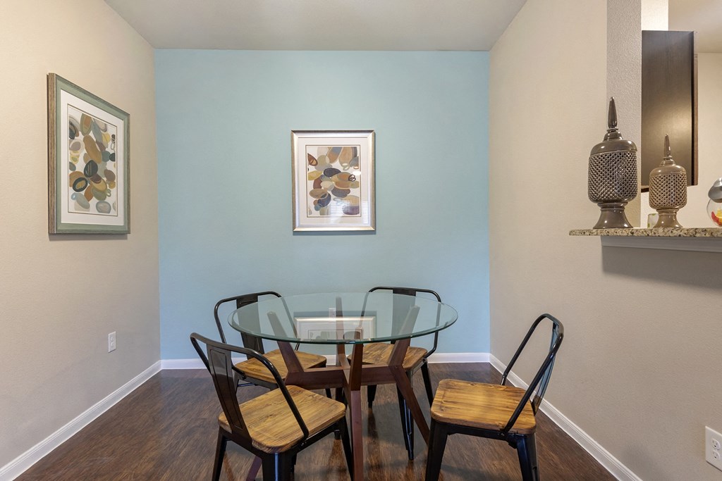 A dining room with a glass table and chairs.