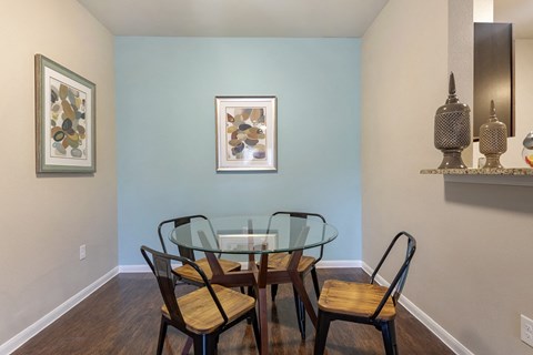 A dining room with a glass table and chairs.